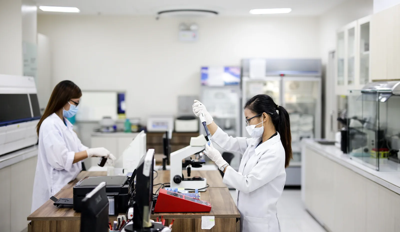 Two scientists in white lab coats working at a laboratory bench in Mexico